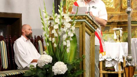 Uczestnik uroczystości stoi przy ambonie, przemawia do zebranych gości