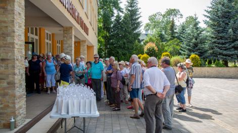 Seniorzy zebrali się na placu przed domem kultury, wita ich przewodnicząca HRK
