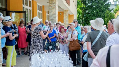Seniorzy zebrali się na placu przed domem kultury, wita ich przewodnicząca HRK