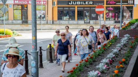 Grupa seniorów idzie po ulicach miasta Hrubieszów