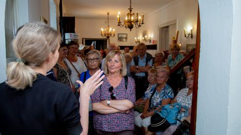 Seniorzy zwiedzają muzeum im. St. Stanisława Staszica, oprowadza ich kustosz Dorota Grzymała