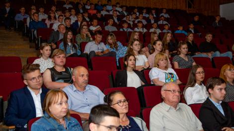 Uczestnicy wydarzenia siedzą na widowni, słuchaja przemówienia