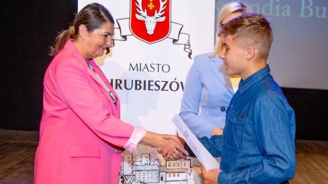Kobieta gratuluje chłopcu nagrody.