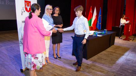 Marta Majewska gratuluje chłopcu nagrody, dyplom wręczy Anna Naja Przewodnicząca Rady Miasta