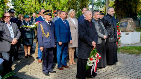 Ludzie stoją w rzędach, przygotowani są do składania kwiatów