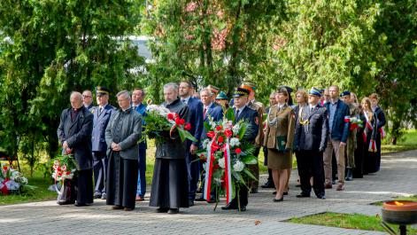 Grupa ludzi w oczekiwaniu na swoją kolej złożenia kwiatów