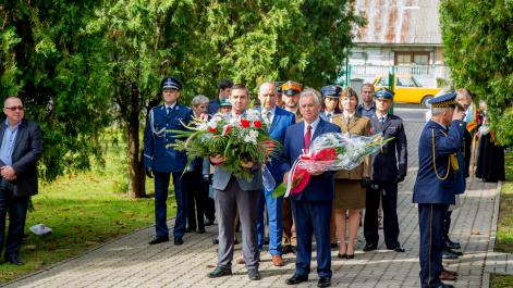 Delegacja dwóch mężczyzn, jeden trzyma wieniec