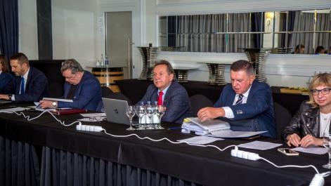 Trzech mężczyzn siedzi przy stole, pracują