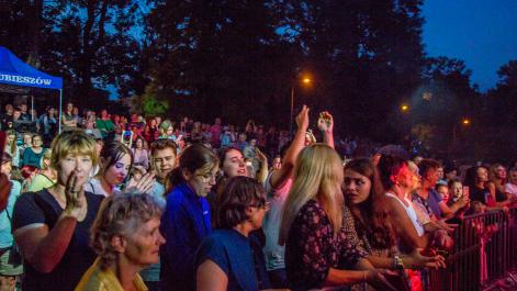 publiczność ogląda koncert, pomiędzy nimi stoi niebieski namiot z logami miasta