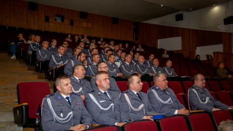 Policjanci siedzą na sali widowiskowej, obserwują wydarzenia na scenie