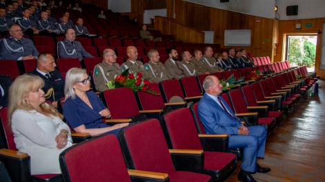 Policjanci siedzą na sali widowiskowej, obserwują wydarzenia na scenie