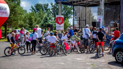 Spora grupa rowerzystów stoi przed sceną, obserwują co się tam dzieje