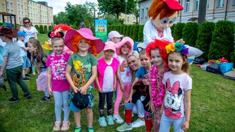 Hrubcio i dzieci ubrane w kolorowe nakrycja głowy pozują do zdjęcia