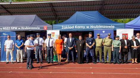 Oficjalni przedstawiciele służb mundurowych i władz miasta i powiatu, sotją na tle granatowych namiotów