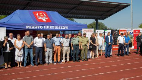 Oficjalni przedstawiciele służb mundurowych i władz miasta i powiatu, sotją na tle granatowych namiotów