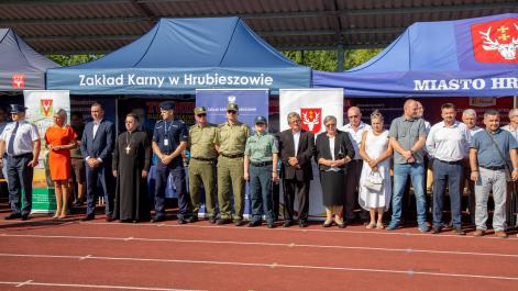 Oficjalni przedstawiciele służb mundurowych i władz miasta i powiatu, sotją na tle granatowych namiotów
