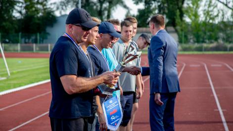 Mężczyzna ogląda puchar, który otzrymał przed chwilą