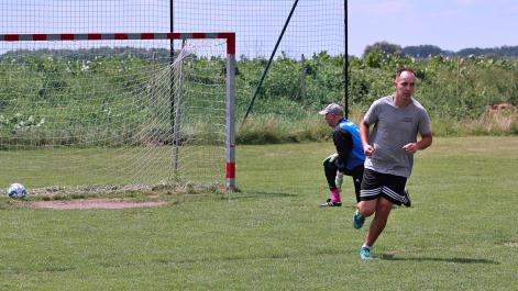 Bramkarz klęczy, piłkarz odbiega w stronę przeciwną, jest gol